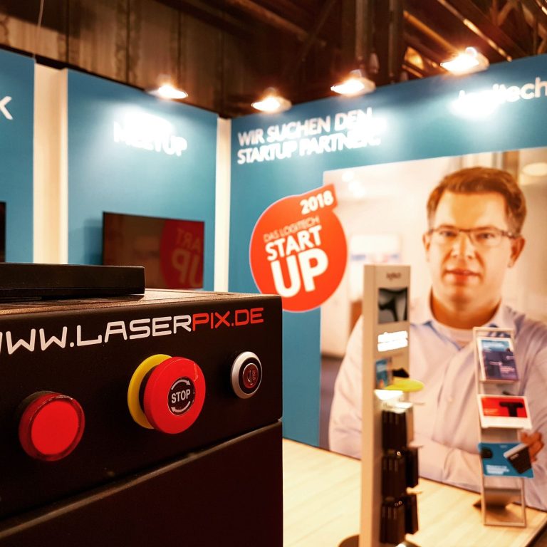 Logitech messe Laserpix Stand von Laserpix am Messestand mit Geräten und prominenter Werbung.